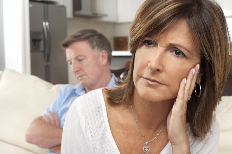 Close up of mature couple fighting sitting on sofa