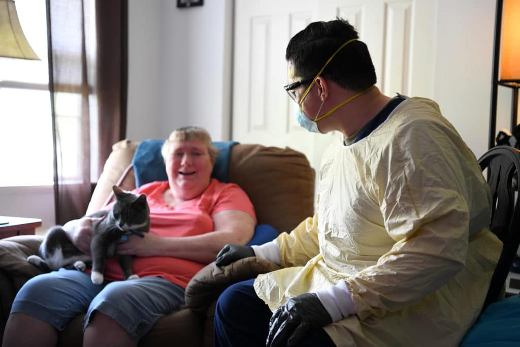 Staff Sgt. Mark Young (right), a financial management specialist assigned to the 121st Air Refueling Wing, talks to Kathy Russell, a resident of the Carlin House, May 27, 2020, in Logan, Ohio. Young was part of a 20-person team of Ohio National Guard members who were tasked with helping at the assisted living facility after over half of their staff and residents tested positive for COVID-19. (U.S. Air National Guard photo by Staff Sgt. Amber Mullen)