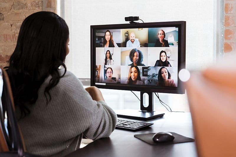A group of diverse persons participate in a virtual meeting