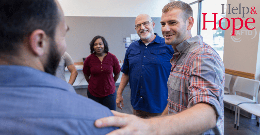 People standing in a circle offering support to one another