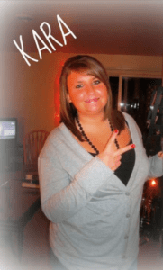 Photo: Kara Kirby, smiling to the camera and giving a peace sign.