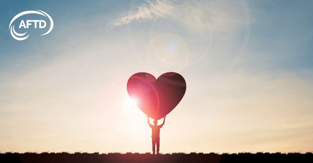 Graphic: figure holding large heart over head, AFTD logo in top corner